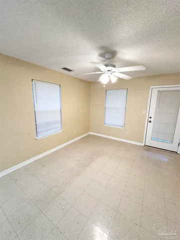 an empty room with a ceiling fan and a window