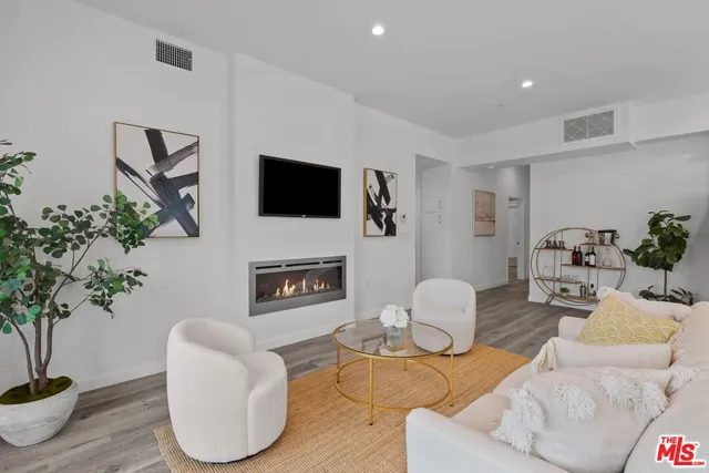 a living room with furniture a potted plant and a fireplace