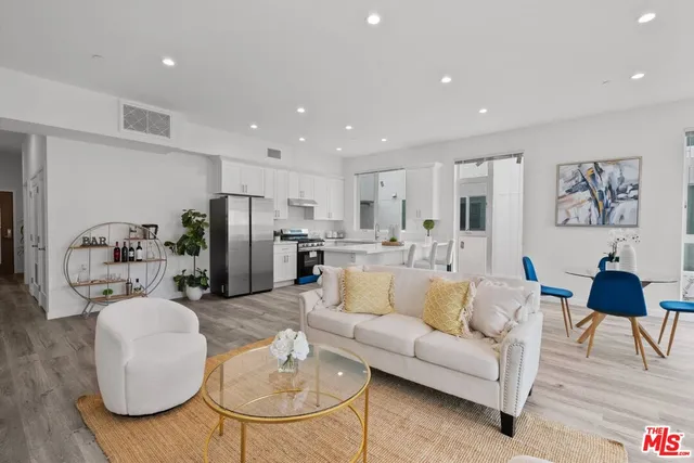 a living room with furniture kitchen view and a refrigerator