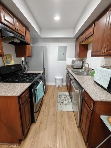 a kitchen with granite countertop a sink stove and cabinets