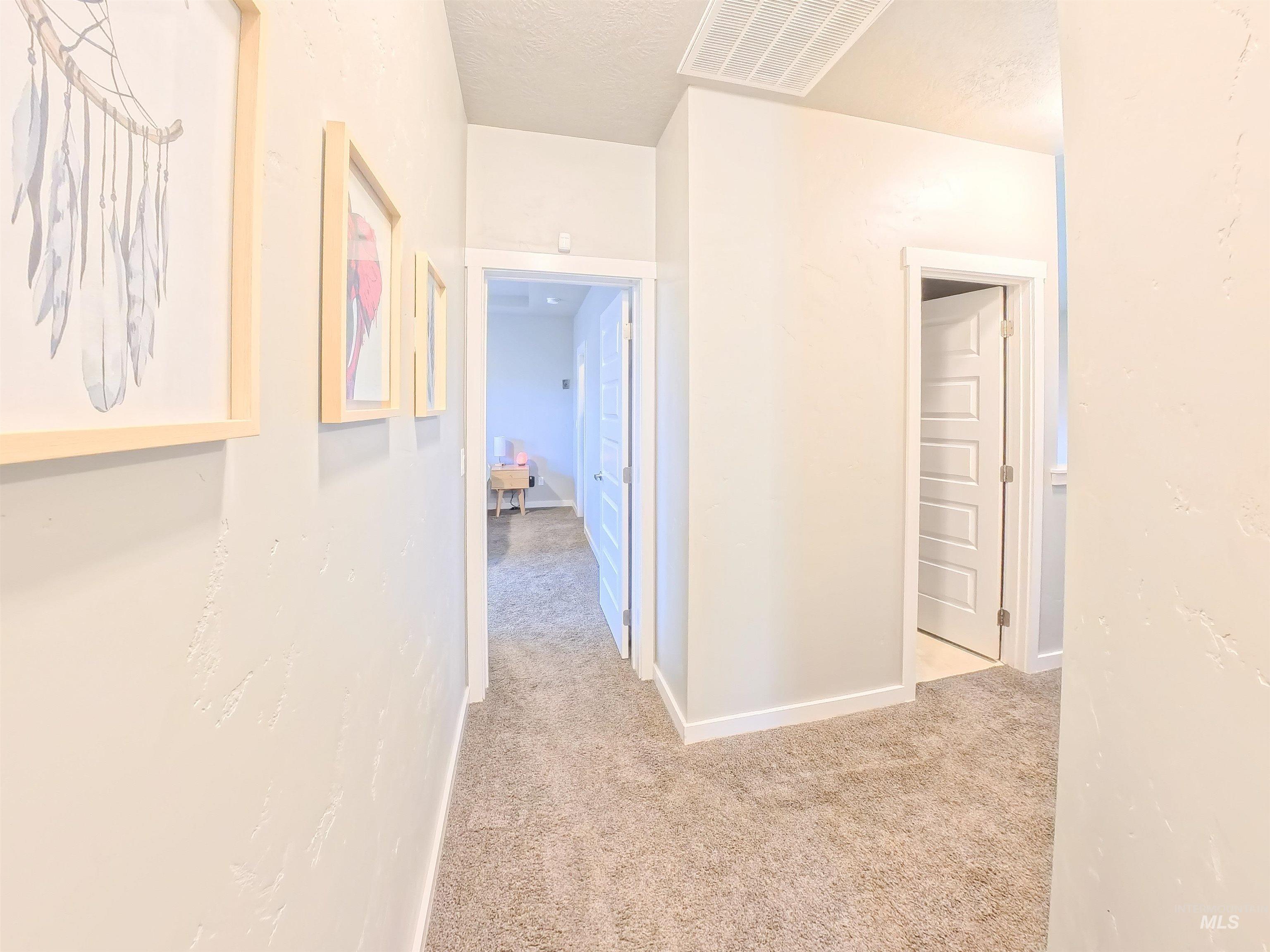 347 South Truss Lane Meridian, ID 83642 - Photo 11 of 24 Hallway featuring light colored carpet and a textured ceiling