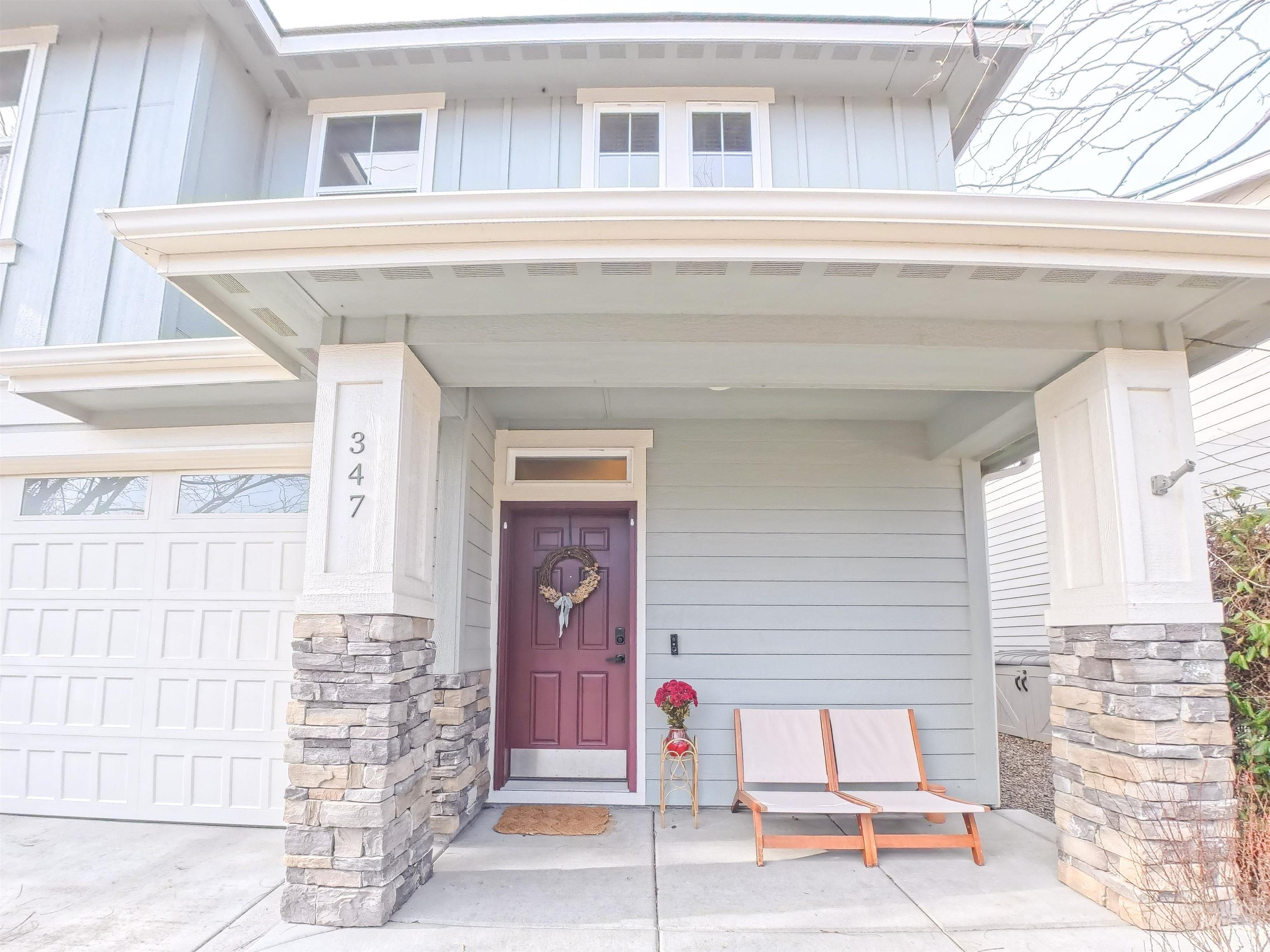 347 South Truss Lane Meridian, ID 83642 - Photo 2 of 24 Doorway to property featuring board and batten siding, a porch, stone siding, and driveway
