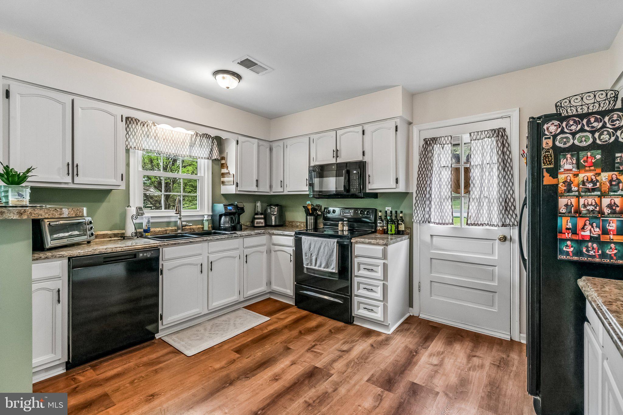 6774 Grays Mill Road Warrenton, VA 20187 - Photo 17 of 35 a kitchen with a refrigerator stove and white cabinets