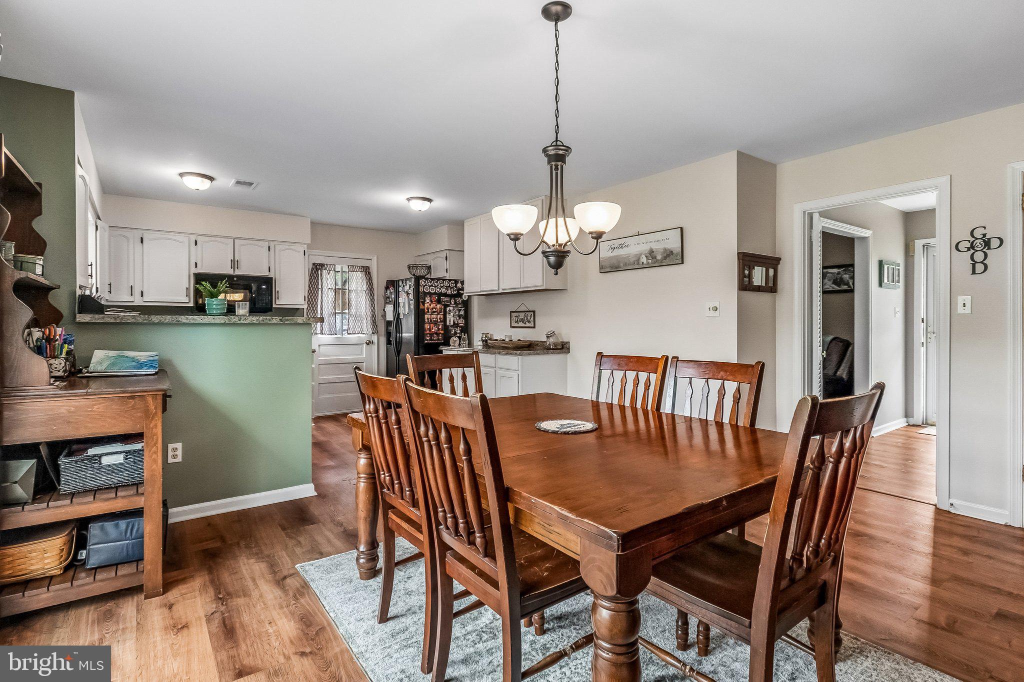 6774 Grays Mill Road Warrenton, VA 20187 - Photo 22 of 35 a view of a dining room and livingroom with furniture wooden floor a rug a painting and a chandelier