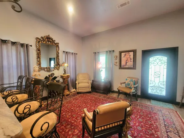 a large room with stainless steel appliances lots of wooden furniture a rug kitchen view and living room view