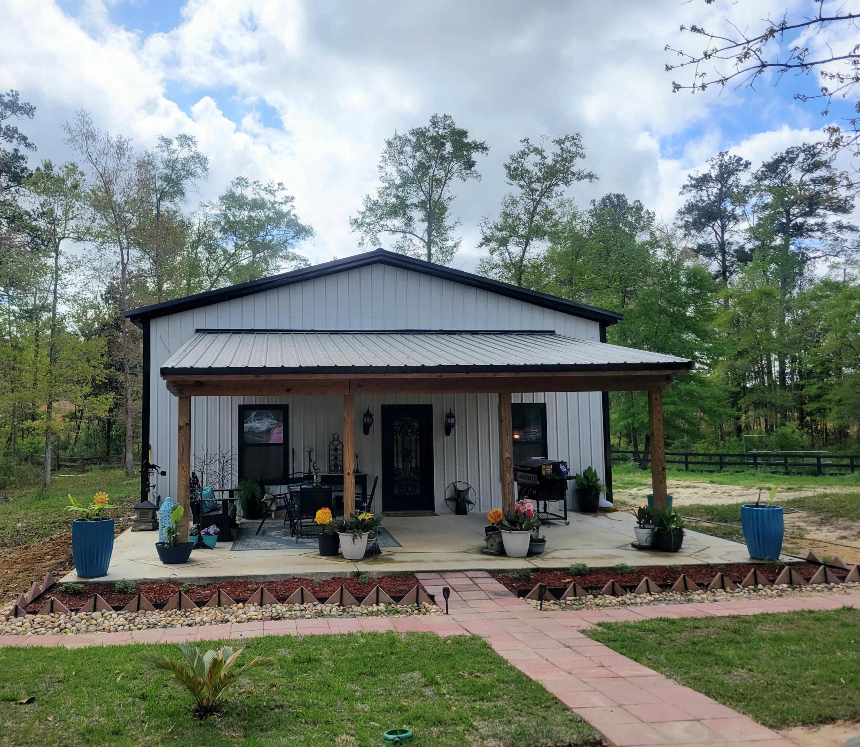 1508 Crooked Creek Road Ponce de Leon, FL 32455 - Photo 3 of 62 a view of a patio with table and chairs under an umbrella