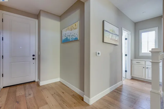 a view of a hallway with wooden floor and staircase