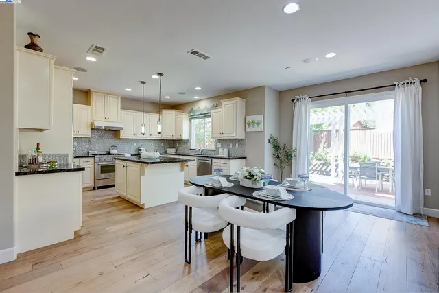 a kitchen with granite countertop white cabinets and stainless steel appliances