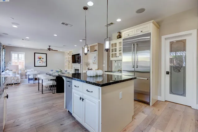a kitchen with stainless steel appliances granite countertop a sink and a white cabinets