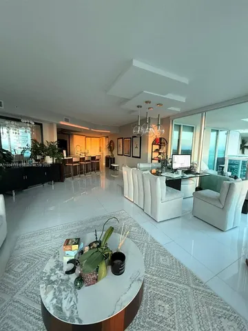 a living room with furniture and a kitchen view