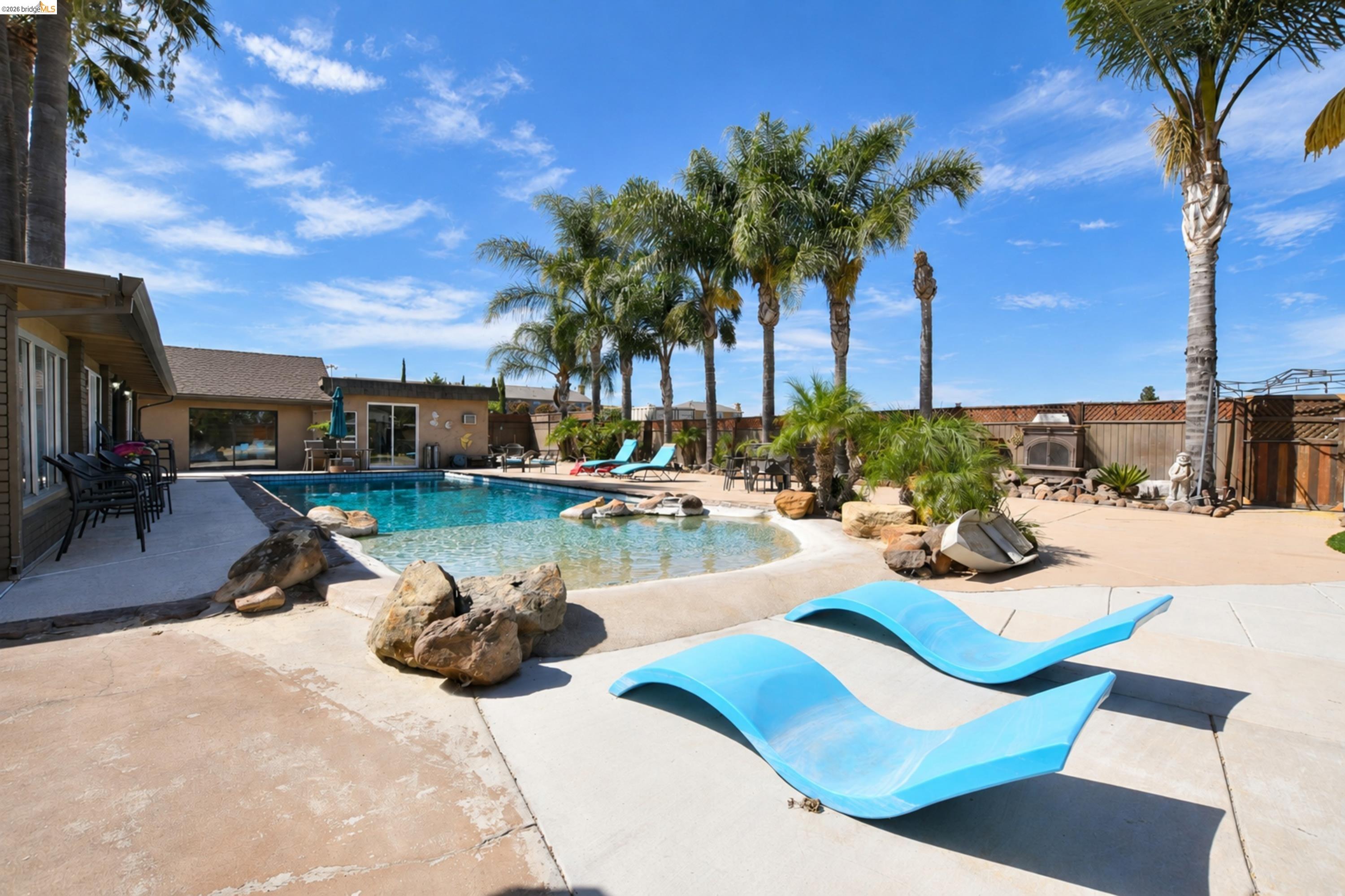 340 West Bolton Road Oakley, CA 94561 - Photo 60 of 87 Large swimming pool with integrated spa and rock features, surrounded by extensive concrete patio areas