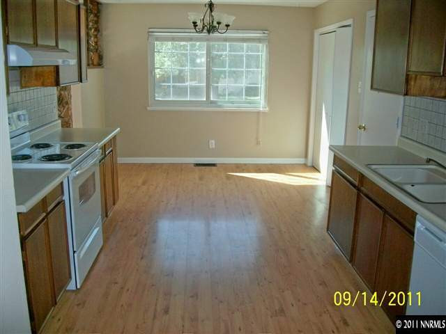 654 Beldon Way Reno, NV 89503 - Photo 5 of 13 a kitchen with granite countertop a stove and a refrigerator