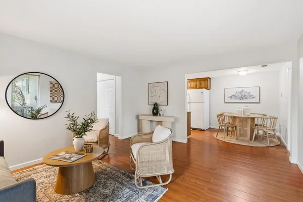 a kitchen with stainless steel appliances granite countertop a stove top oven a sink dishwasher and white cabinets with wooden floor