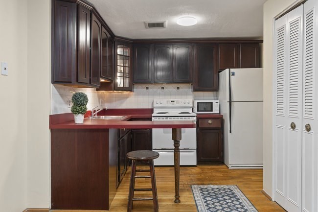 357 Faneuil Street, Unit 12 Boston, MA 02135 - Photo 7 of 15 a kitchen with stainless steel appliances a refrigerator and a stove top oven