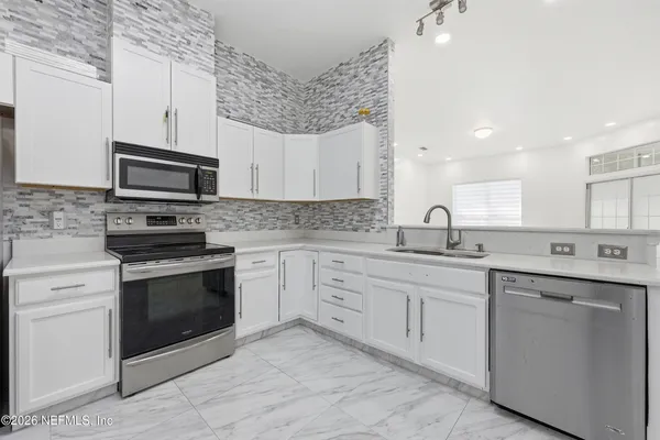 a kitchen with stainless steel appliances granite countertop a stove top oven a sink and dishwasher