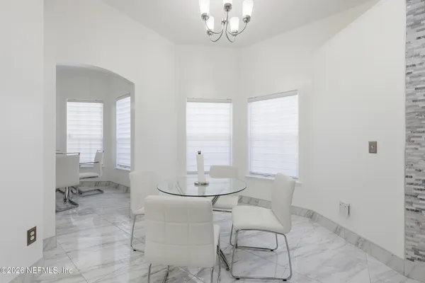 a view of a dining room with furniture and a chandelier