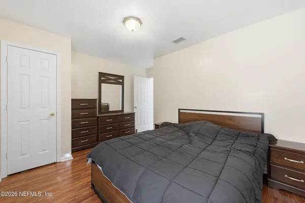 a bedroom with a bed and wooden floor