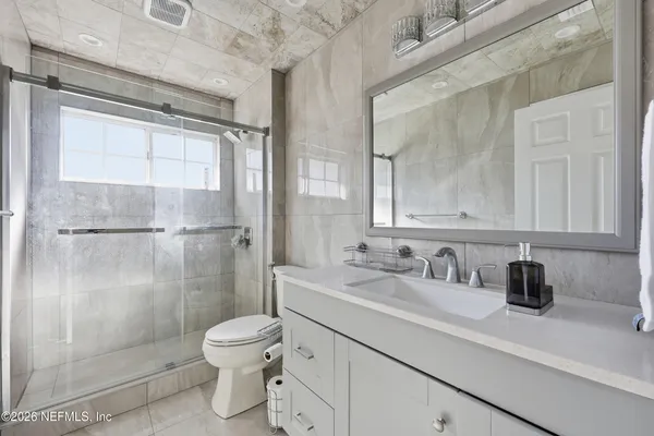 a bathroom with a sink a toilet and shower