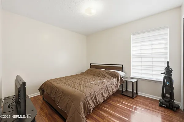 a bedroom with a bed next to a window with chair