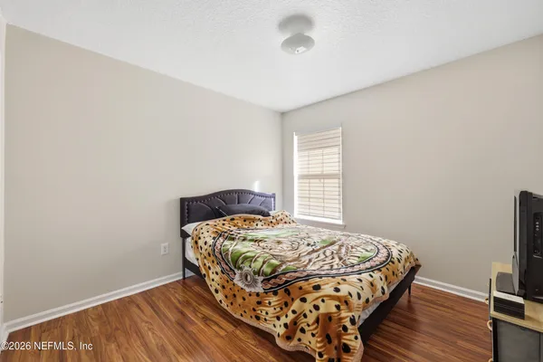 a bedroom with a bed and wooden floor