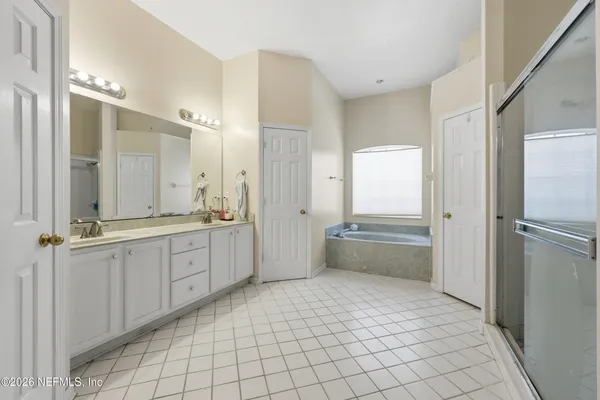 a spacious bathroom with a mirror a shower and a bathtub