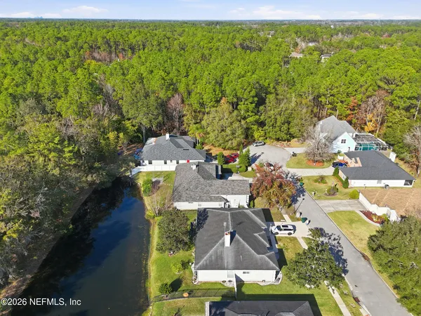 an aerial view of residential house with outdoor space and trees all around