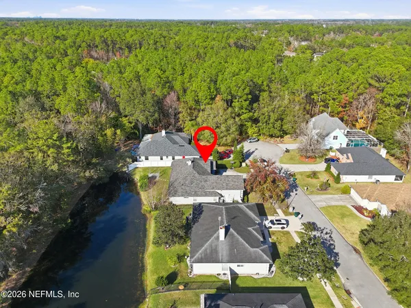 an aerial view of residential houses with outdoor space and trees
