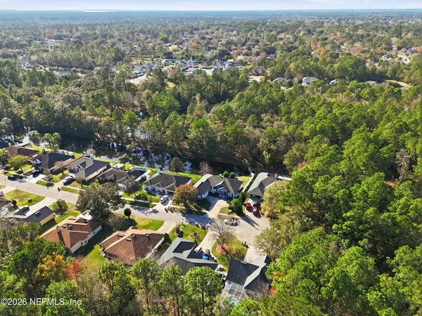 an aerial view of residential houses with outdoor space and trees
