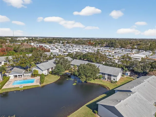 an aerial view of residential houses with outdoor space and trees