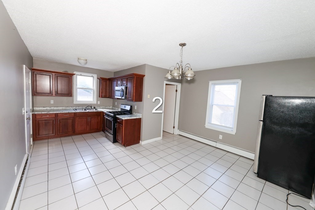 459 Snell Street Fall River, MA 02721 - Photo 12 of 42 a kitchen with stainless steel appliances granite countertop a stove top oven a sink a counter space and cabinets