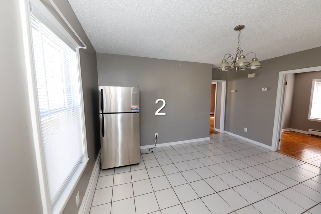 459 Snell Street Fall River, MA 02721 - Photo 13 of 42 a view of a kitchen with a refrigerator and wooden floor