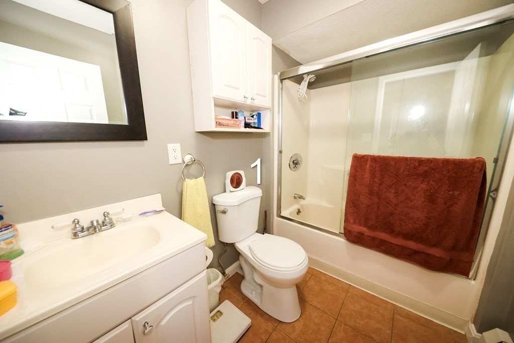 459 Snell Street Fall River, MA 02721 - Photo 18 of 42 a bathroom with a toilet sink and a shower curtain