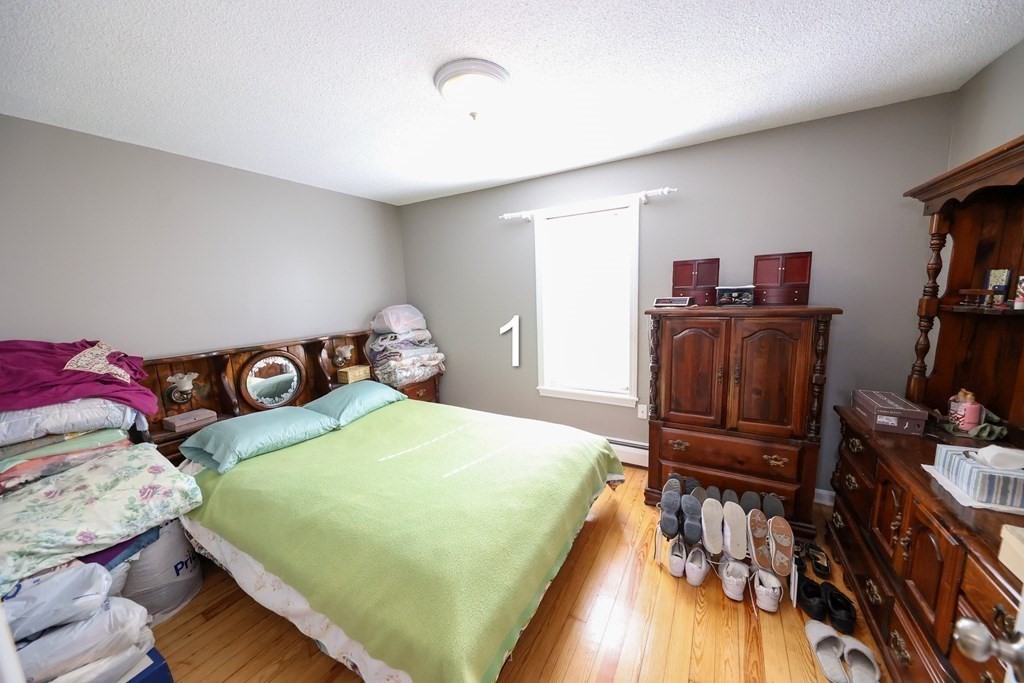 459 Snell Street Fall River, MA 02721 - Photo 19 of 42 a bedroom with a bed and wooden floor