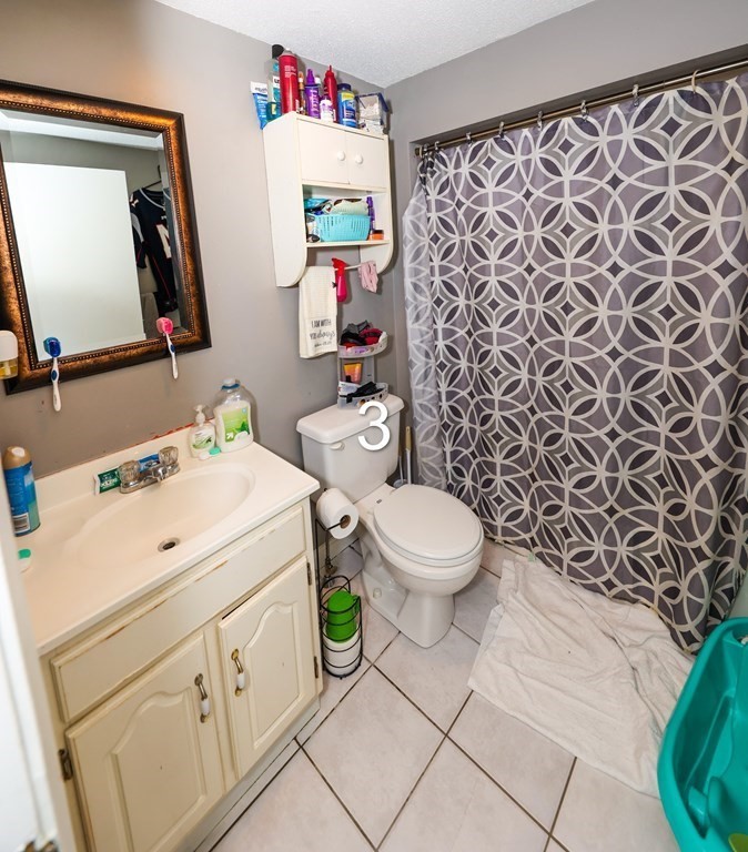 459 Snell Street Fall River, MA 02721 - Photo 24 of 42 a bathroom with a toilet sink vanity and mirror