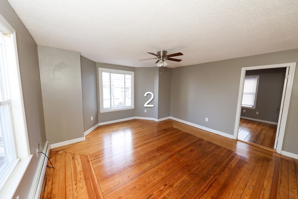 459 Snell Street Fall River, MA 02721 - Photo 3 of 42 a view of empty room with wooden floor and fan