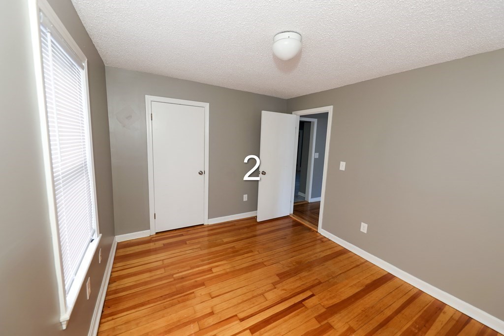 459 Snell Street Fall River, MA 02721 - Photo 9 of 42 a view of an empty room with wooden floor and a window