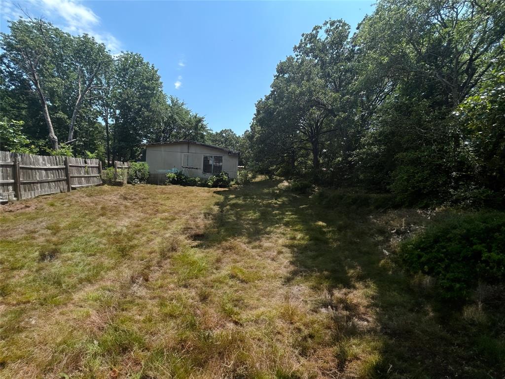 120 Timber Trail Mabank, TX 75156 - Photo 9 of 12 a view of backyard with large trees and wooden fence