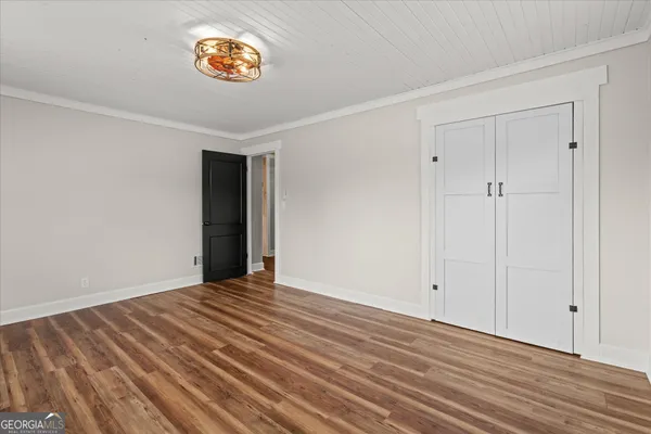 a view of an empty room with wooden floor
