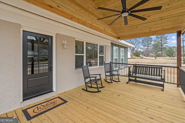 a view of a patio with a table chairs and wooden floor