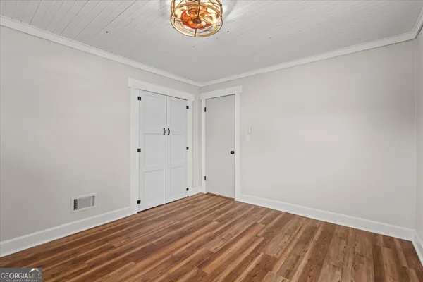 a view of a room with wooden floor and a window