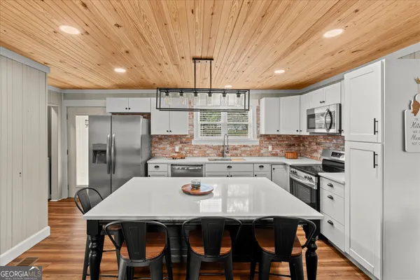a kitchen with kitchen island a refrigerator stove microwave and cabinets