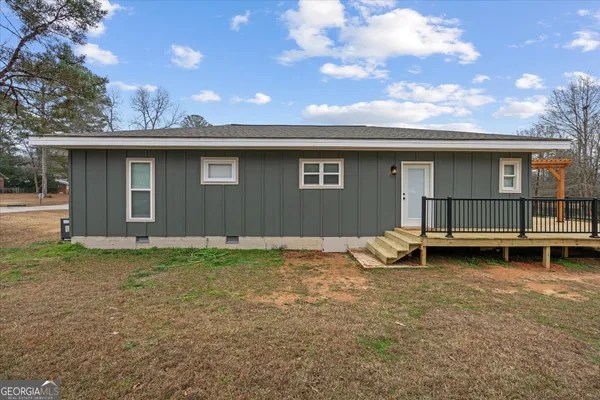 a backyard of a house with barbeque oven and table and chairs
