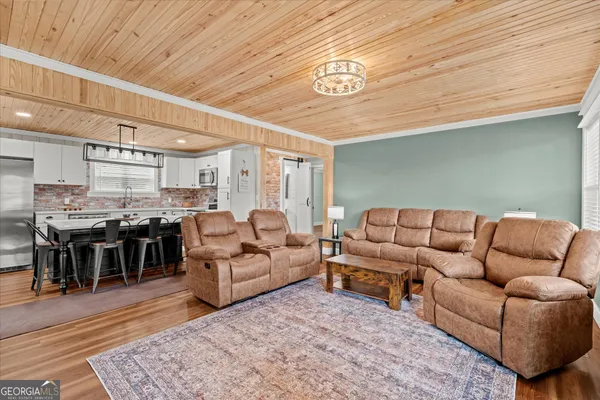a living room with lots of furniture and kitchen view