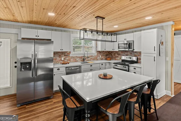 a kitchen with a table chairs refrigerator and microwave