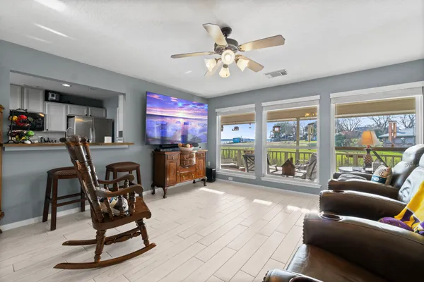 a living room with furniture a floor to ceiling window and a flat screen tv