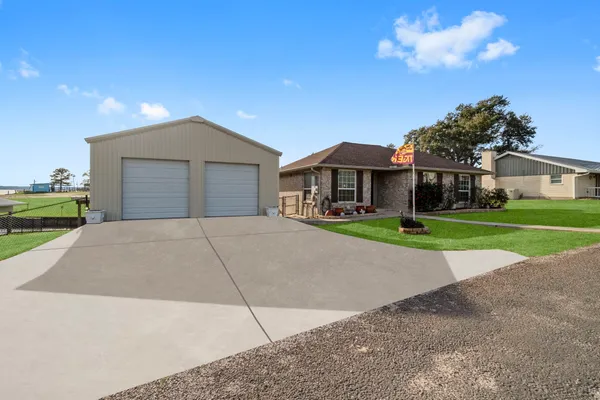 a front view of a house with a yard and trees