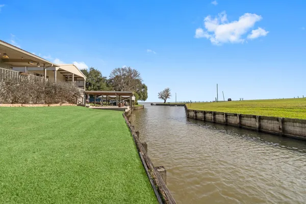 a view of a swimming pool with lawn chairs under an umbrella