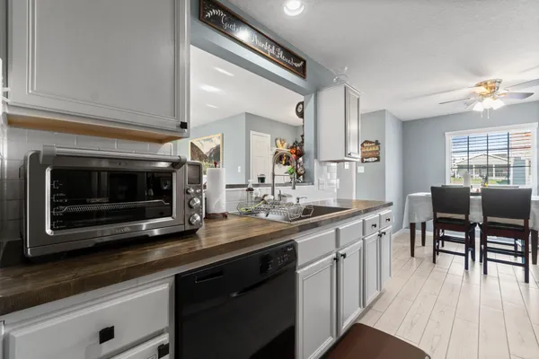 a kitchen with stainless steel appliances a stove a sink cabinets and a dining table
