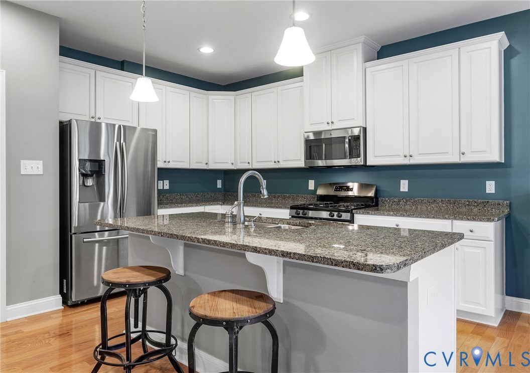 3437 Kendal Crossing Terrace Midlothian, VA 23113 - Photo 12 of 31 a kitchen with stainless steel appliances granite countertop a stove a sink a refrigerator with white cabinets and wooden floor