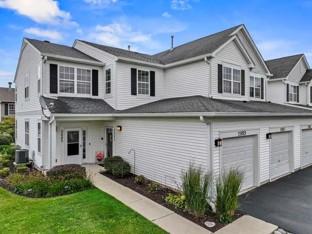 a front view of a house with a yard and potted plants